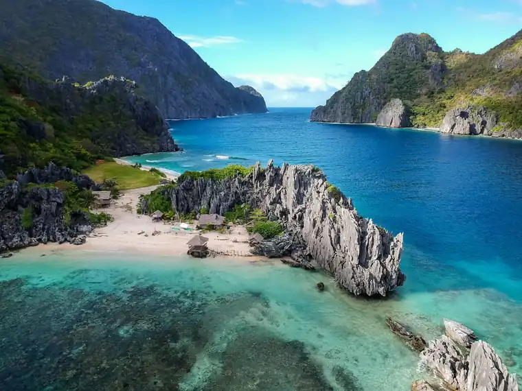 Vista aérea de uma pequena ilha verde rodeada de mar turquesa